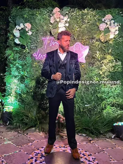 A client looking dapper in a black patterned three-piece suit. This is a perfect choice for an evening reception, offering a subtle texture that catches the light beautifully.
