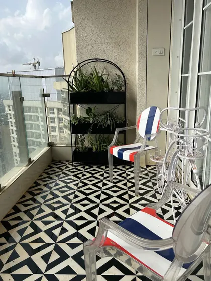 This custom-designed plant rack is a perfect solution for small balconies. It utilizes vertical space to house a variety of plants like aloe vera and spider plants, set against a striking geometric floor pattern.