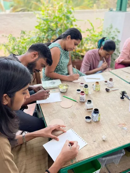 Adults engaged in a focused art workshop on our rooftop. The calm, natural setting helps everyone relax and sink into their creative process.
