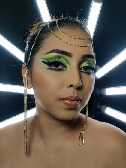 This is a dramatic Arabic-style eye makeup look. I used shades of bright green and a sharp, extended black winged liner to create this classic, glamorous shape, adorned with a glittery finish.