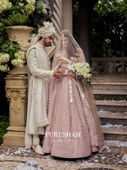 A quiet moment between a couple, where my design plays a supporting role. The groom's white sherwani, with its subtle all-over embroidery, is designed to harmonize perfectly with the bride's pastel lehenga, creating a picture of timeless elegance.