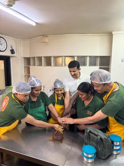 All hands in! Cutting the cake together to celebrate our one-year milestone. This picture perfectly captures our spirit of teamwork and togetherness.