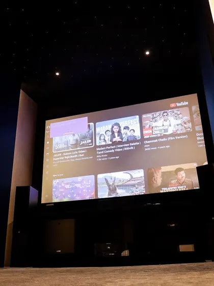 The view from the front of the room, showing the large screen and the clean, uncluttered layout that makes the space feel larger.