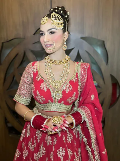 A classic pose showing the front view of the red lehenga and the intricate details of the jewellery and blouse.