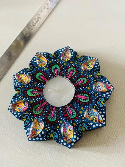 This floral-shaped candle holder in a deep blue is another one of my favorites. The intricate patterns and colorful gems make it a beautiful decorative piece.