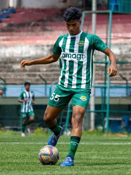 A player demonstrates composure on the ball, controlling the midfield with a referee and stadium backdrop adding to the professional feel.