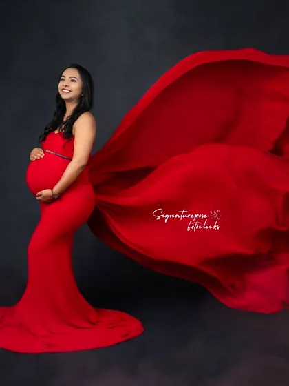 The flowing red fabric creates a sense of motion and drama in this elegant side-profile studio shot.