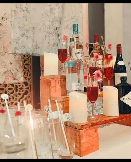 A closer view of the romantic bar setup, highlighting the custom stirrers and the way the candlelight reflects off the glassware. It's all about creating a warm and inviting atmosphere.