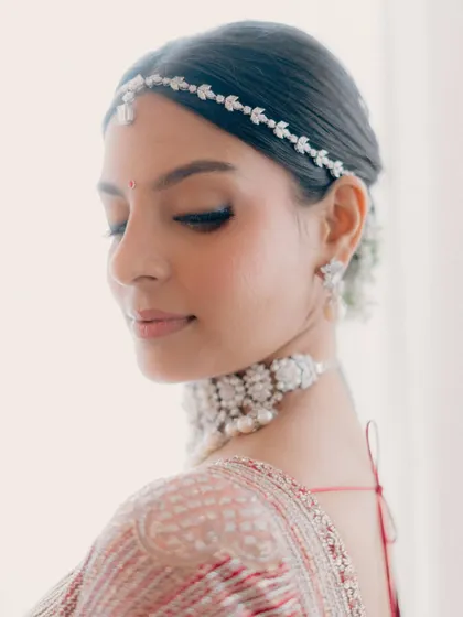 A close-up of a modern phera look. The skin is the star here, with a beautiful, dewy finish. The eye makeup is minimal, with just a simple line and mascara to define the lashes.