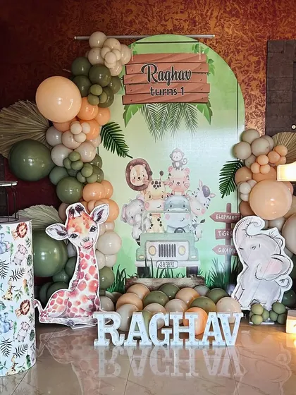 A gentle and sweet Jungle theme for a first birthday, using pastel green and peach balloons with adorable animal graphics.