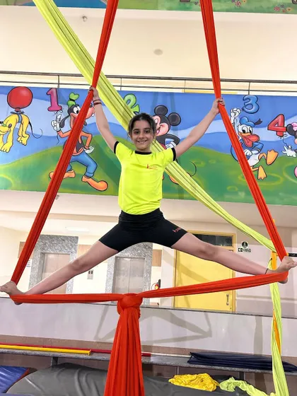 Holding a wide split within a triangle formed by the silks, this student shows excellent control and flexibility.