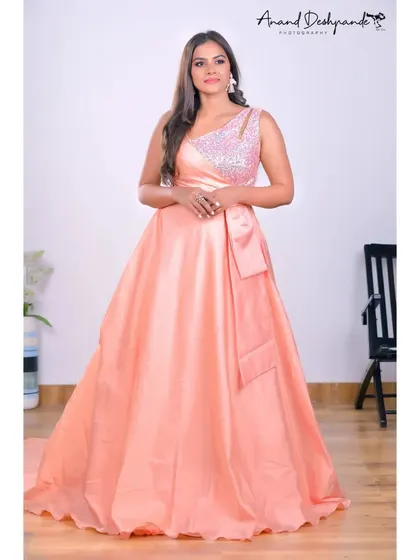 A full-length shot of the peach ball gown, showing its beautiful trail and elegant design.