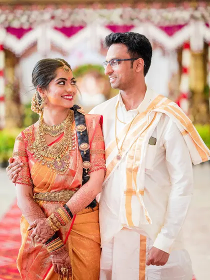 A classic wedding portrait showing the couple's beautiful smiles and traditional attire. The bride's glance towards the groom makes this a truly special moment.