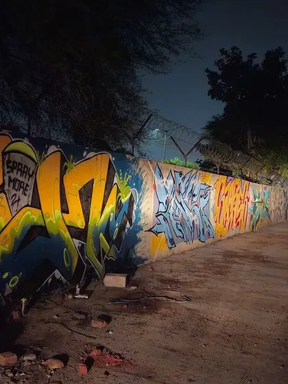 A night shot of a completed wall from a 'Spray More' session with my homies. The colors pop against the dark background.