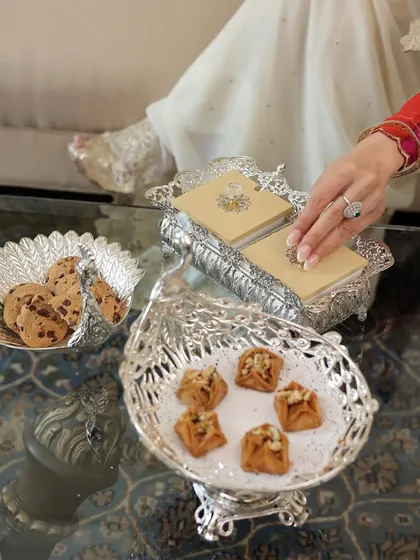 A masterpiece of grace from my Mijaaz collection. This peacock-shaped silver serving tray, holding traditional sweets, brings a story of heritage and royal finesse to your table setting.