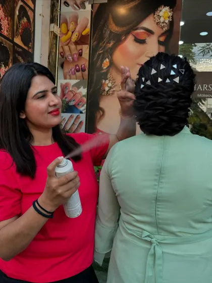 Ritu at work, perfecting the textured bun with hairspray to ensure it holds its shape all day and night.