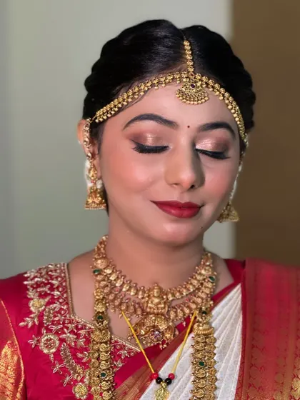 A close-up of the eye makeup. The blend of gold and bronze tones with a sharp winged liner creates a look that is both traditional and captivating.