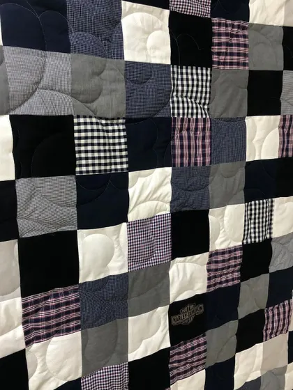 A detailed view of the checkerboard shirt quilt, showing the gentle, curved quilting pattern.