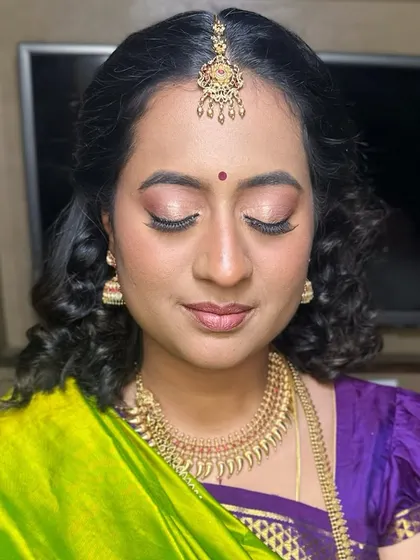 For this look, I focused on creating a simple, subtle, and skin-like finish. The makeup enhances her natural features with soft curls and a traditional nine-yard saree.