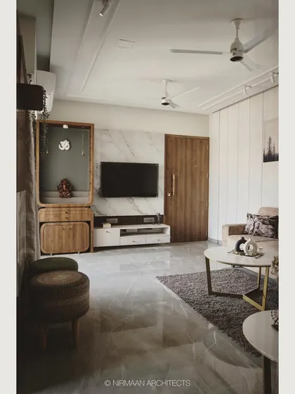 In this living room, we combined a marble-clad media wall with a wooden pooja mandir. This creates a harmonious balance between modern aesthetics and traditional values, all within a clean and uncluttered layout.