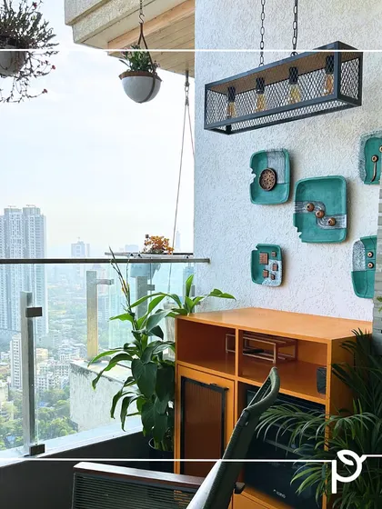 A cozy and stylish balcony corner designed for relaxation. We used hanging planters, wall-mounted pots, and unique furniture to maximize the small space, creating a personal nook with a beautiful city backdrop.