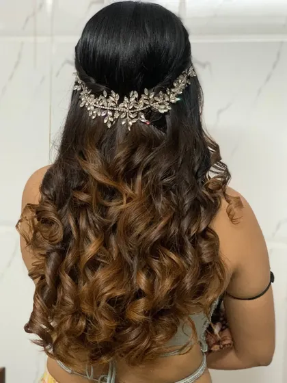 Texture curls for this bridesmaid. This half updo is accentuated with a beautiful leafy hair accessory, perfect for a wedding guest look.