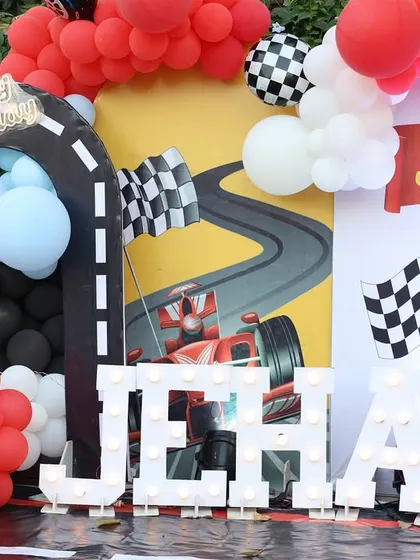 A close-up of the car-themed stage, featuring light-up letters spelling the birthday boy's name, Jehaan.