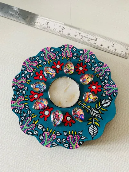A teal floral candle holder, hand-painted with delicate patterns and adorned with my signature art-printed gems.