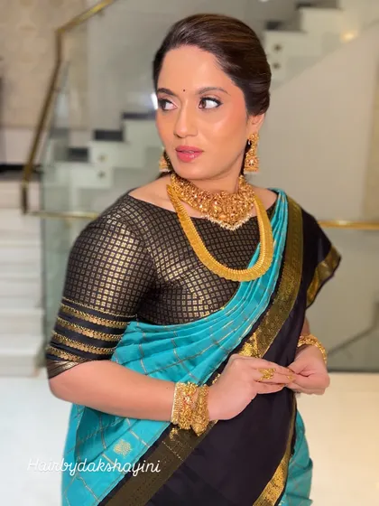 This client is ready for her event. The black and blue saree is draped perfectly, with the pleats neatly in place, ensuring she looks flawless from every angle.