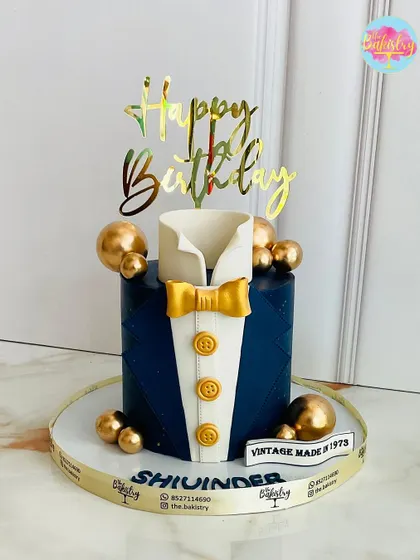 A custom cake for the modern gentleman. This one features a navy blue tuxedo design with a gold bow tie, celebrating a "Vintage Made in 1973."