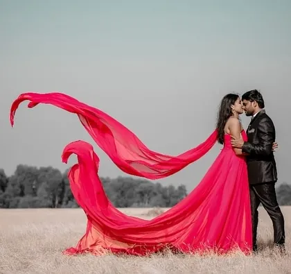 This pink flying gown creates a breathtaking effect in an open field. It's a fantastic choice for couples who want epic, cinematic shots for their pre-wedding album.