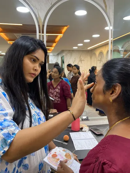 In my self-grooming classes, I provide direct, hands-on guidance. Here, I'm showing a student the correct placement for concealer to brighten the under-eye area without it looking heavy.