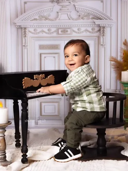 A joyful shot of a little boy looking right at the camera, ready to create his first masterpiece.