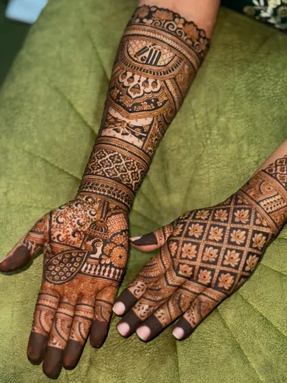 A gorgeous bridal design featuring a mix of grid patterns and traditional motifs. The peacocks on the palms are a classic symbol of beauty and grace in wedding mehendi.