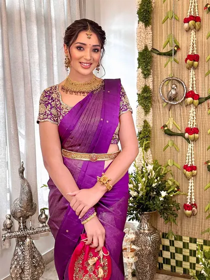A beautiful look for a Pellikoduku event. The makeup is traditional yet soft, complementing the rich purple saree and gold jewellery.