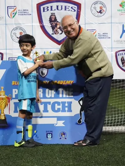 This young player is all smiles as he receives his "Player of the Match" trophy. These small moments of recognition make a big difference.