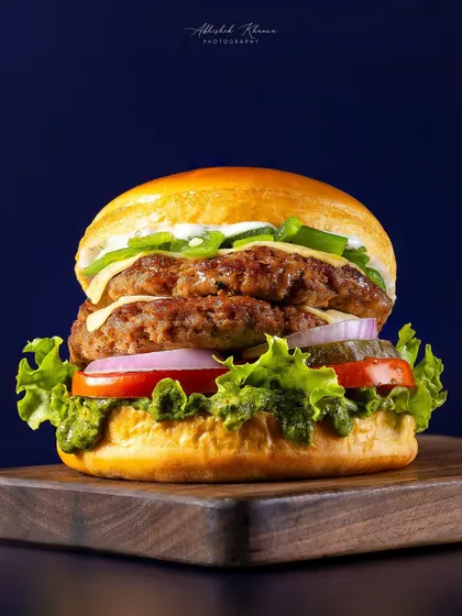 A classic double-patty smash burger, captured for Chili's 'Smasher Burgers' campaign. The focus is on creating a visually appealing, mouth-watering image that performs well for advertising and online menus, highlighting the texture of the patties and freshness of the ingredients.