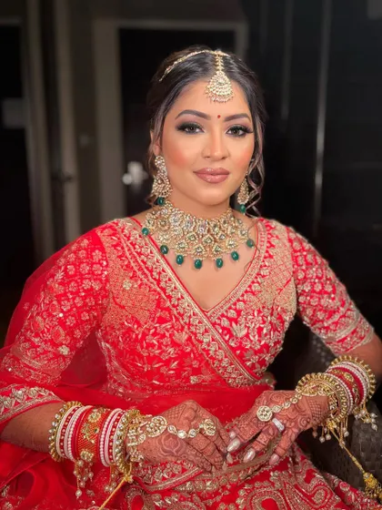 A beautiful portrait of Krisha, ready for her wedding. The makeup is perfectly harmonized with her red and green jewelry and intricate henna design.
