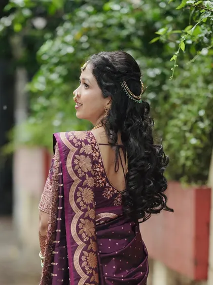 Another view of the romantic, curly hairstyle. The delicate hair accessory adds a touch of sparkle to this beautiful engagement look.
