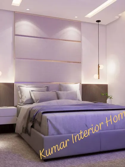 A luxurious bedroom with a large, upholstered headboard featuring metallic inlay details. The soft, purple-toned lighting creates a relaxing mood.