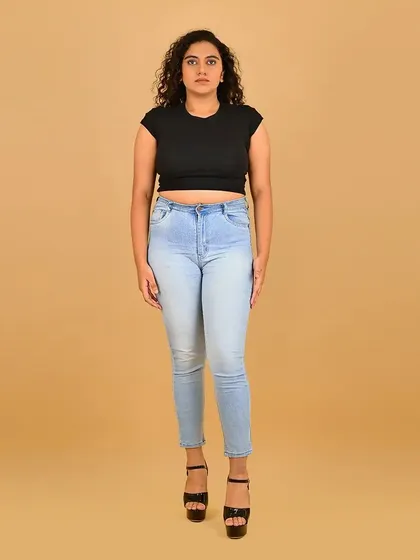 A full-length shot for a model with beautiful curly hair. The makeup is kept clean and fresh to complement her natural look.