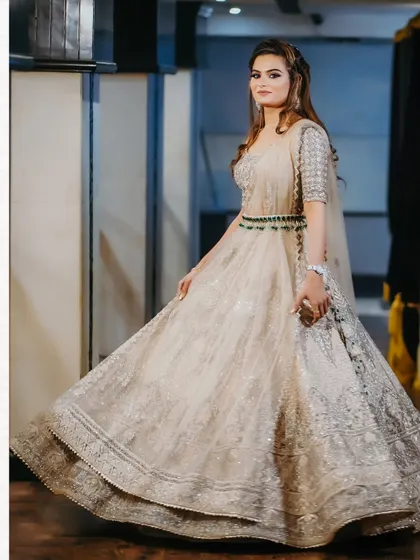 A full-length shot of the bride, showing the beautiful flare of her embellished lehenga. Her confident pose and the elegant setting make for a perfect bridal portrait.