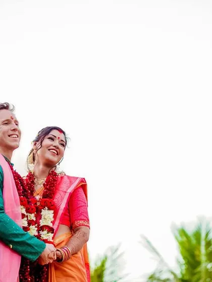 A minimalist portrait with a feeling of hope and new beginnings. The couple looks up towards the sky, where two birds fly freely, symbolizing their journey.