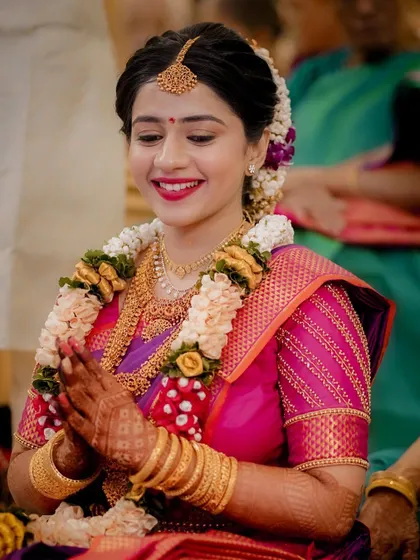The bride with her hands joined in a gesture of respect and prayer during her traditional engagement ceremony.