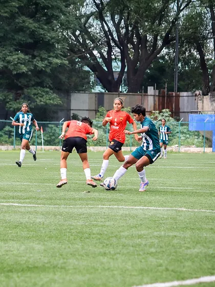 A player prepares to make a pass while being pressured by two opponents, showcasing quick decision-making under pressure.