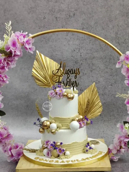 This non-fondant boho wedding cake is one of our favorites. We created a beautiful display using a custom floral hoop, delicate gold leaf accents, and a modern tiered structure. It’s a perfect example of how we can create a breathtaking centerpiece for your special day without using fondant.