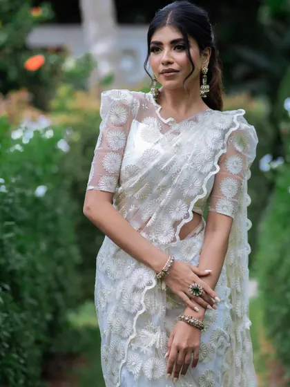 A close-up of the white saree, highlighting the intricate self-embroidery.