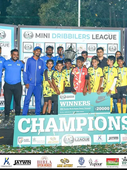 Our U13 team celebrating with the trophy and a winners cheque after being crowned champions of the Mini Dribblers League.