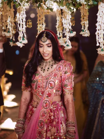 A close up of Pallavi's bridal look, showing the detailed embroidery on her lehenga and the soft glam makeup.