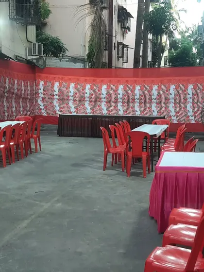 A simple outdoor dining setup with tables and chairs. This is perfect for community lunches or festival prasad distribution.